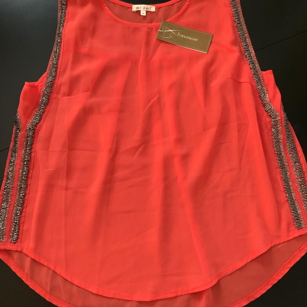 Francesca’s orange tank top blouse.